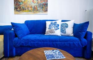 - un canapé bleu avec deux oreillers et une table dans l'établissement Unique apartment in Glyfada center, à Athènes