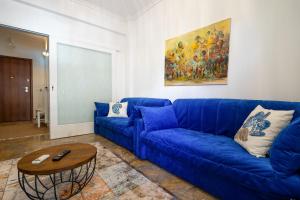 - un canapé bleu dans le salon avec une table dans l'établissement Unique apartment in Glyfada center, à Athènes