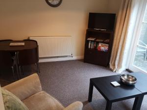 a living room with a couch and a table and a piano at Coastal Escape Deal - 2 Bedroom House at Kent Escapes Short Lets & Serviced Accommodation Kent, Wifi in Deal