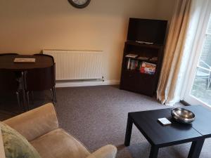 a living room with a couch a table and a television at Coastal Escape Deal - 2 Bedroom House at Kent Escapes Short Lets & Serviced Accommodation Kent, Wifi in Deal