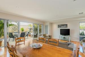 a living room with a table and a television at Ocean Keys Cottage - Free WiFi in Mindarie