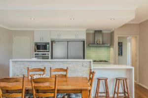 a kitchen with a wooden table and four chairs at Ocean Keys Cottage - Free WiFi in Mindarie