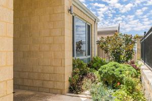 a house with a garden next to a building at Ocean Keys Cottage - Free WiFi in Mindarie