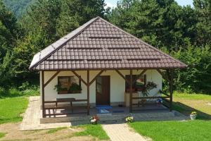 un pequeño cenador con un banco en un patio en Limpedea Green House, en Baia Mare