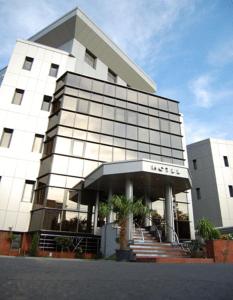 a large white building with stairs in front of it at Acapulco Hotel in Ploieşti