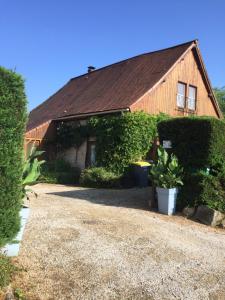 a house with a roof and a gravel driveway at Les Tachats in Hautefort