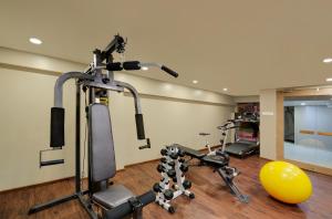 a gym with two tread machines and a ball at Central Beacon Hotel in Surat