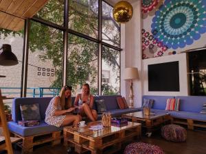 Dos mujeres sentadas en un sofá en una sala de estar en STAY Rhodes Hostel & Bar, en Rodas