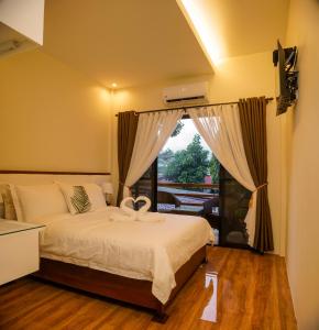 een slaapkamer met een bed en een groot raam bij Amigos Dauin Hostel in Dauin
