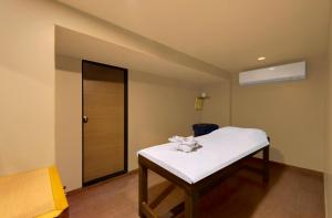 a small room with a bed and a door at Central Beacon Hotel in Surat
