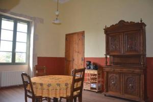 a dining room with a table and a wooden cabinet at Ancienne Abbaye de Franquevaux Camargue in Franquevaux
