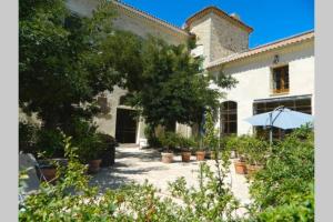 a white building with potted plants in front of it at Ancienne Abbaye de Franquevaux Camargue in Franquevaux