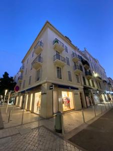 a large white building on a city street at night at Cannes Holiday Suites in Cannes