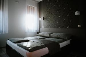 A bed or beds in a room at Németh Apartmanházak