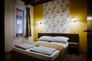 Un dormitorio con una cama con paredes amarillas y una ventana en Németh Apartmanházak en Mórahalom