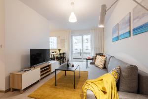 un soggiorno con divano e TV di P&O Serviced Apartments MORDOR a Varsavia