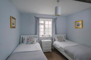 two twin beds in a room with a window at Corffe House and Holiday Cottages in Barnstaple