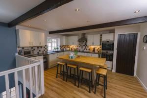 a large kitchen with a wooden table and chairs at Corffe House and Holiday Cottages in Barnstaple