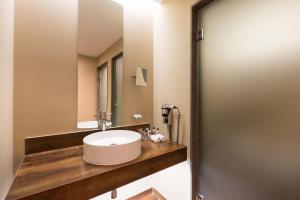 
a bathroom with a sink, toilet and mirror at Morgado Golf & Country Club in Portimão
