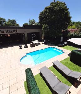 a swimming pool in a yard with chaise lounges at Palm Swift Luxury Accommodation in Brits
