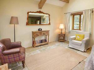 a living room with two chairs and a mirror at Lane Foot Cottage in Lancaster