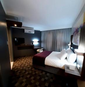 une chambre d'hôtel avec un lit et une télévision dans l'établissement Palm Swift Luxury Accommodation, à Brits