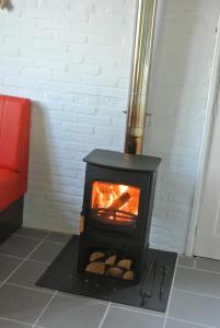 a black stove with logs in a room at B&B Bouwmanshoeve in Burgh Haamstede