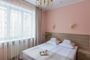 Schlafzimmer mit einem Bett mit weißer Bettwäsche und einem Fenster in der Unterkunft Гостиница Ермак in Krasnojarsk