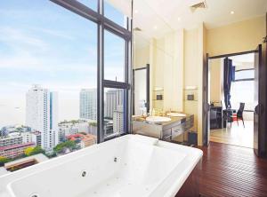 a large bathroom with a large tub and a large window at Siam@Siam Design Hotel Pattaya in Pattaya Central