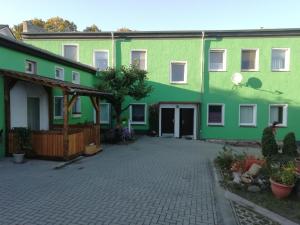 een groot groen gebouw met een binnenplaats bij Alte Försterei in Straupitz