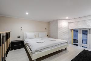 リヴィウにあるFredra apartmentの白いベッドルーム(大型ベッド1台付)が備わります。