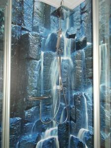 a shower in a bathroom with a waterfall mural at Surek in Soltau