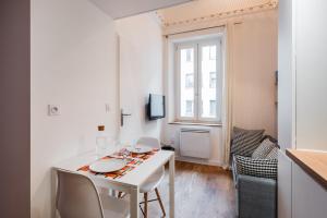 a white dining room with a white table and chairs at DIFY Suchet - Confluence / Perrache in Lyon