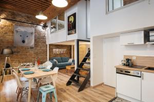 a loft conversions kitchen and living room with a table and chairs at DIFY Bear & Co - Hotel de Ville in Lyon