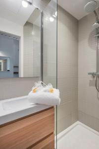 uma casa de banho com um chuveiro e uma toalha no balcão em DIFY Suchet - Confluence / Perrache em Lyon
