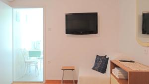 a living room with a television on a wall at STUDIO MIMI CENTER OF TOWN KRK CROATIA in Krk