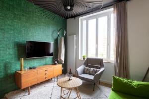 a living room with a television and a chair at DIFY Art Déco - Charpennes in Villeurbanne