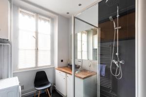 La salle de bains est pourvue d'une cabine de douche en verre. dans l'établissement DIFY Masséna - Brotteaux, à Lyon