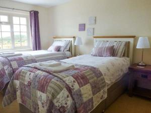 1 dormitorio con 2 camas y ventana en Primrose Cottage, en Malton