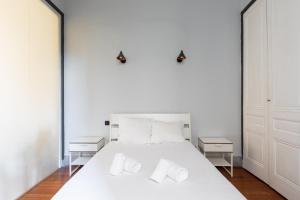 - une chambre blanche avec un lit blanc et 2 tables de chevet dans l'établissement DIFY Masséna - Brotteaux, à Lyon