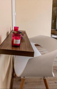a table with a white chair and a jar on it at BougainVilla Guest House in King Williamʼs Town +21 photos