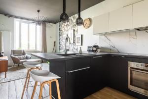 a kitchen with a sink and a counter with stools at DIFY Art Déco - Charpennes in Villeurbanne