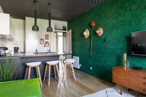 eine Küche mit grünen Wänden und Barhockern in der Unterkunft DIFY Art Déco - Charpennes in Villeurbanne