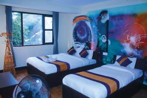 a room with two beds and a painting on the wall at Rest Up Kathmandu Hostel in Kathmandu
