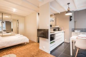 a room with a bed and a kitchen with a tv at DIFY Seguin - Confluence / Perrache in Lyon