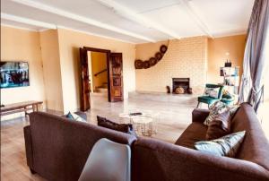 a living room with two brown couches and a fireplace at BougainVilla Guest House in King Williamʼs Town