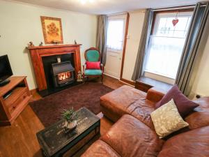 a living room with a couch and a fireplace at Wee Cot in Sandown