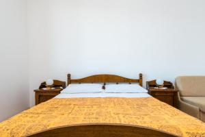 a bedroom with a bed with a yellow comforter at Villa Kukuljica in Zaton
