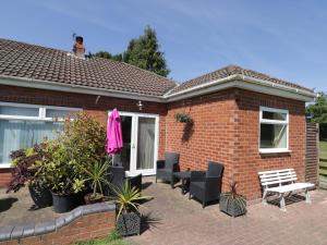 a brick house with black chairs and a bench at The Bungalow in York