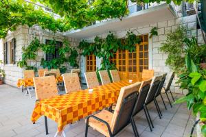 una mesa naranja y sillas en un patio en Villa Kukuljica, en Zaton